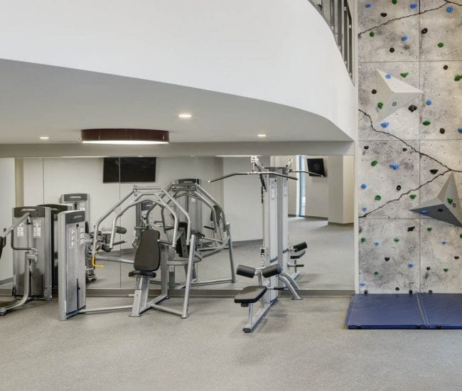 The Kendrick's fitness center including fitness machines and rock climbing wall.